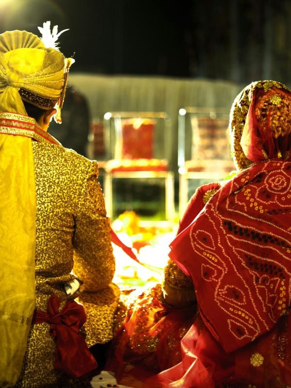 Colorful Indian bride and groom at a traditional wedding ceremony during the night.